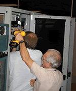 L-Net and DRAGON reps mounting the Movaz RAYexpress unit in rack at GSFC � 1 of 2