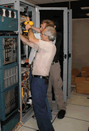 L-Net and DRAGON reps mounting the Movaz RAYexpress unit in rack at GSFC � 2 of 2