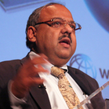 Photo of Nagaraja Rao Harshadeep speaking at podium with The World Bank log on screen behind him