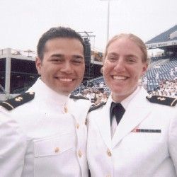 A man with short dark hair and a woman with blonde hair pulled back in white naval uniforms