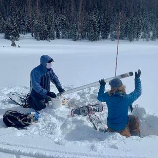 Photo of Randall Bonnell and Lucas Zeller, graduate students at Colorado State University, collecting a snow core sample at Cameron Pass, Colorado. Photo courtesy Dan McGrath, Colorado State University