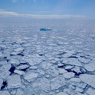 Photo of a lone iceberg amidst sea ice along the coast east of Sermilik Fjord. 