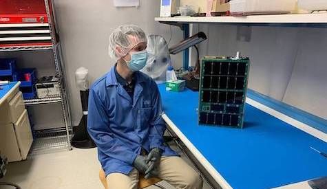 In the lab, CuPID Principle Investigator Brian Walsh admires the satellite