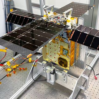 The solar-powered small satellite is shown here with its solar arrays extended in a Georgia Tech clean room.