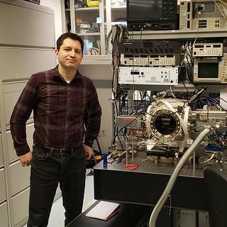 Photo of Adrian Southard next to some lab equipment