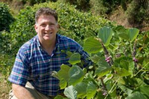 Dr Manuel Lerdau kneeling in kudzu