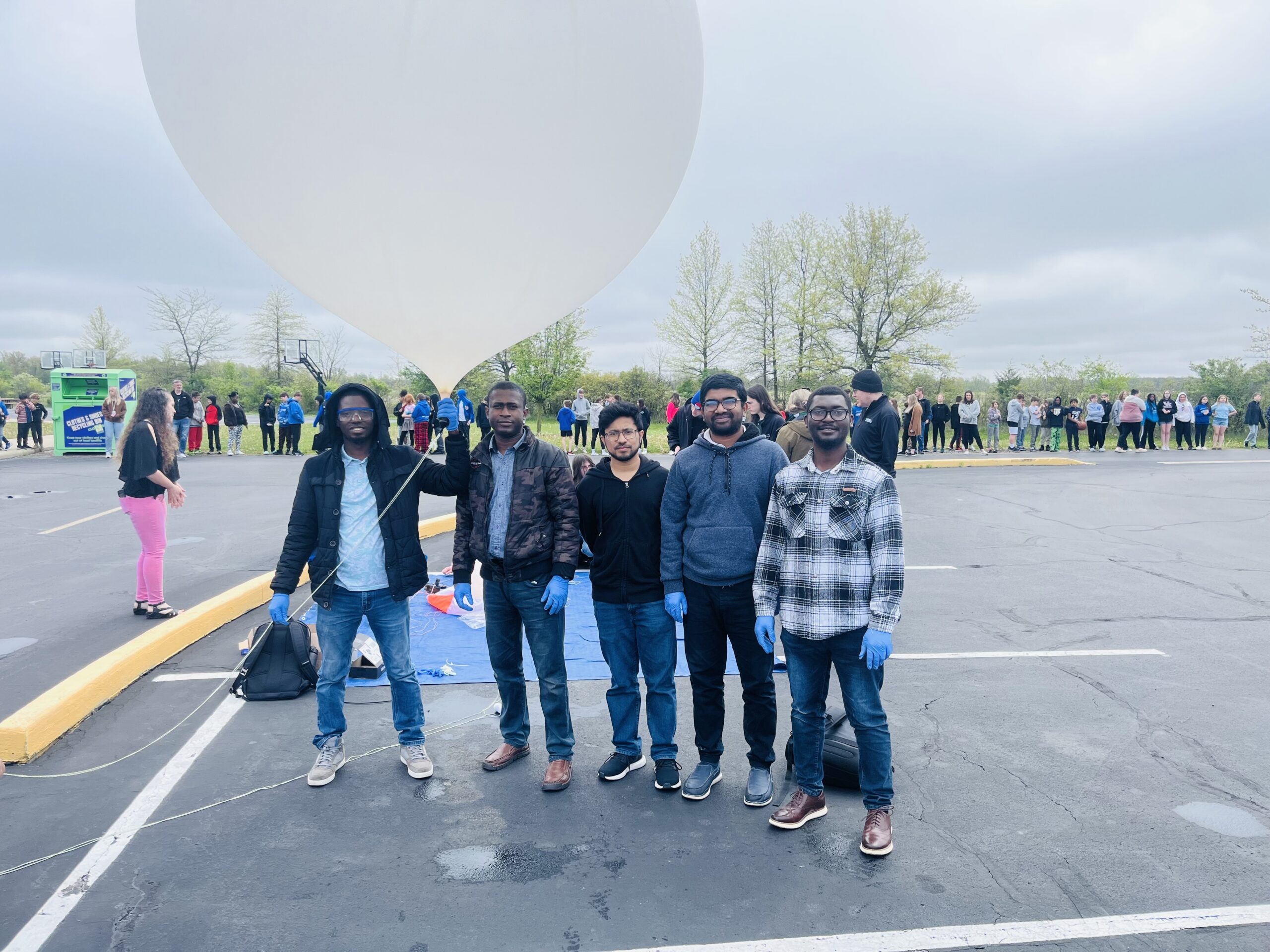 UToledo students (left to right) Yusuf Tayo, Olawale Oluwafemi, Md. Faisal Karim, Hossain Idrish, Stephen Yankyera preparing to launch a high-altitude balloon in front of 300 K-6 students from Defiance Elementary School, Defiance, OH, to test their ThinSat - April 2, 2025.